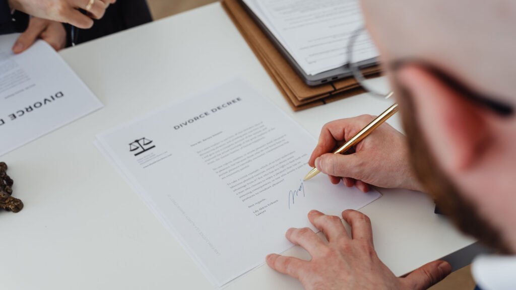 Signing a property transfer document, representing gift deed and family settlement paperwork for NCR property transfers
