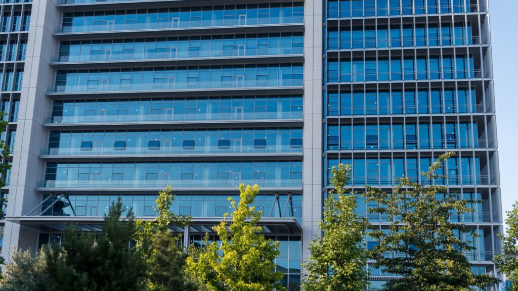 Modern glass-facade commercial office tower, representative of the Grade A office assets held by SM REIT and fractional ownership schemes in India.