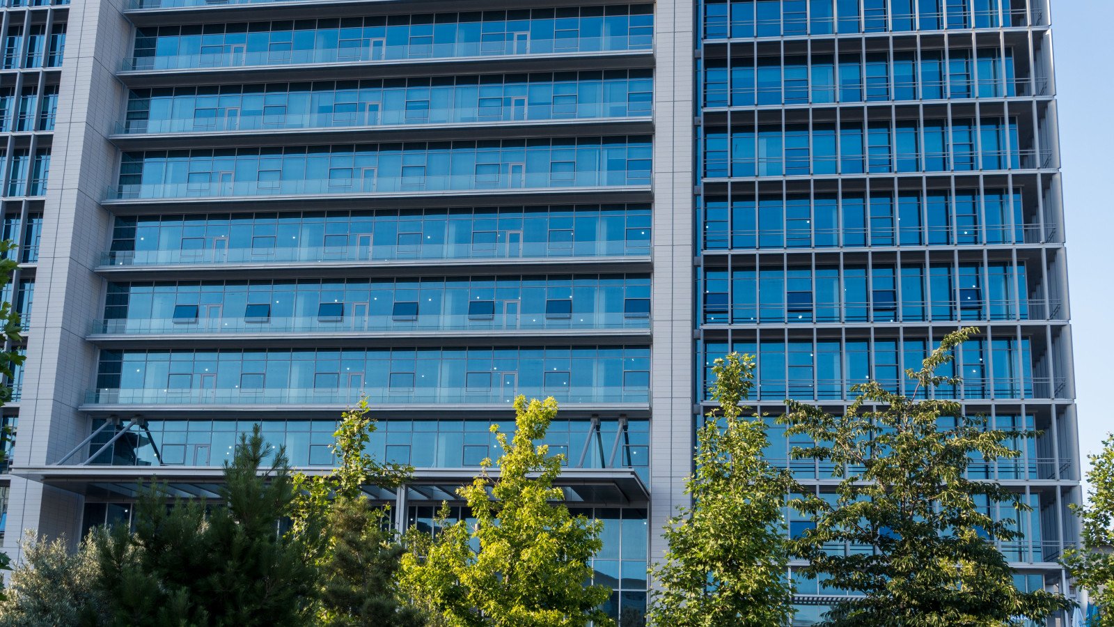 Modern glass-facade commercial office tower, representative of the Grade A office assets held by SM REIT and fractional ownership schemes in India.