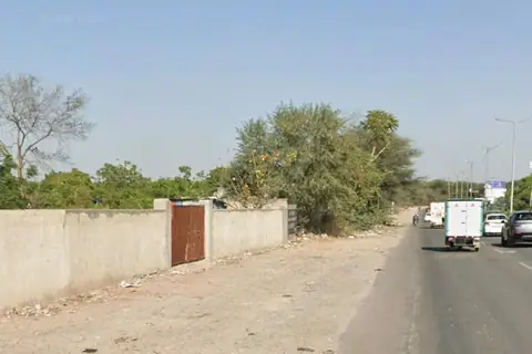 Boundary wall and road frontage of the multi-use land parcel at Gwal Pahari, Gurugram