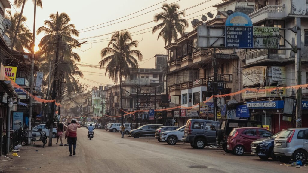 Street scene at sunset in Calangute, North Goa, with palm trees and local shops, representative of the Candolim-Calangute coastal belt compared in this guide